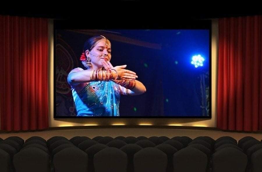 Teatro vuoto con proiezione su uno schermo di ragazza indiana