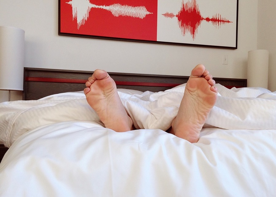 Immagine esempio piedi nudi che spuntano dal letto.