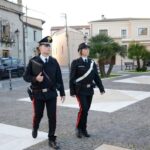 coppia di carabinieri uomo donna che camminano in una piazza