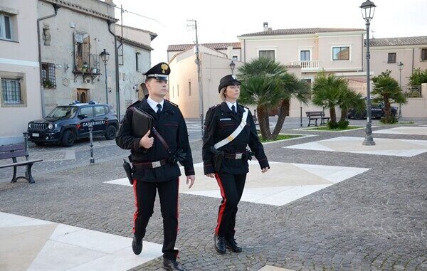 coppia di carabinieri uomo donna che camminano in una piazza