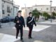coppia di carabinieri uomo donna che camminano in una piazza